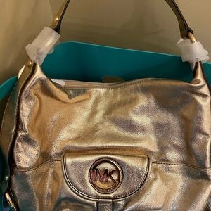 Michael Kors Gold Shoulder Bag with Circular Emblem and Flap Closure